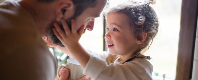 Father caring for his young daughter by giving her a drink, symbolizing family care and support with the legal backing of Astraea Linskills Solicitors Liverpool.