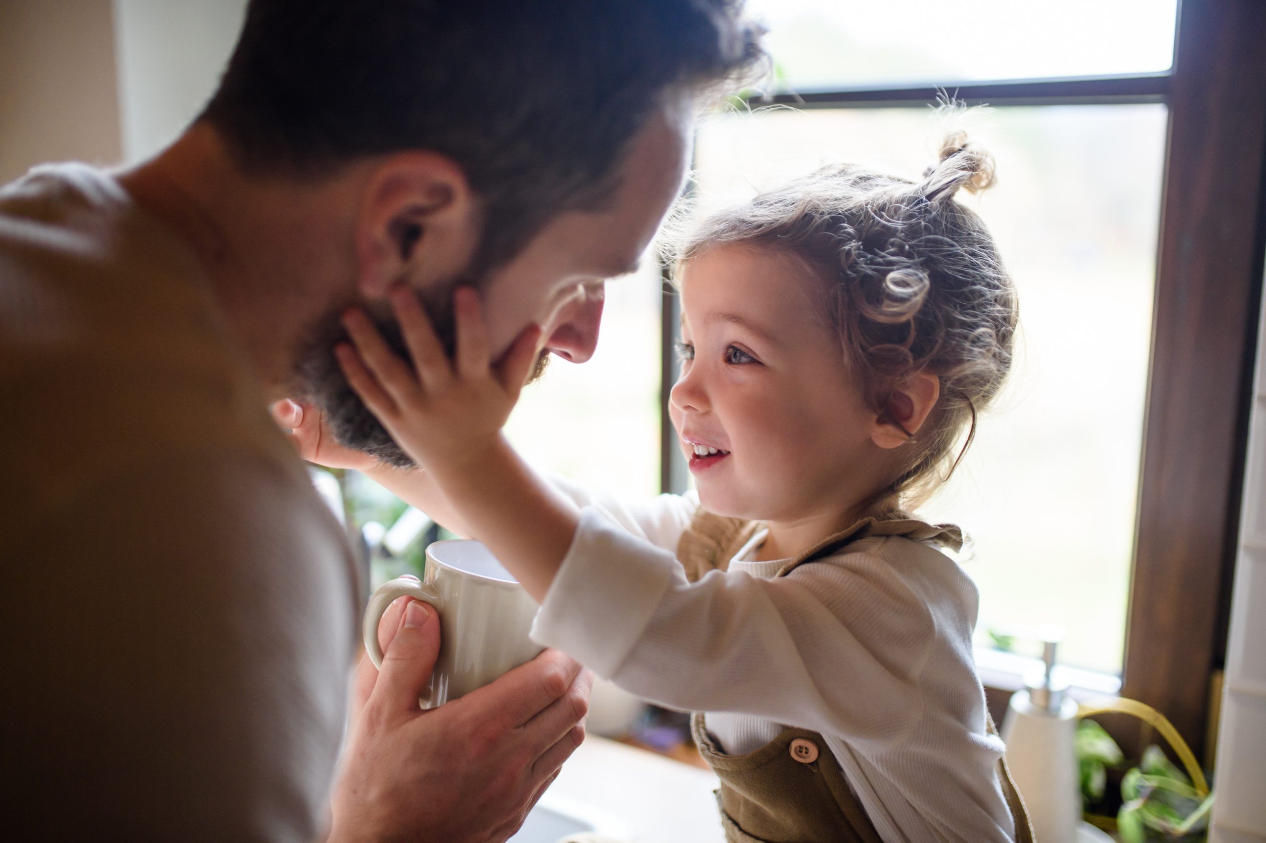 Father caring for his young daughter by giving her a drink, symbolizing family care and support with the legal backing of Astraea Linskills Solicitors Liverpool.